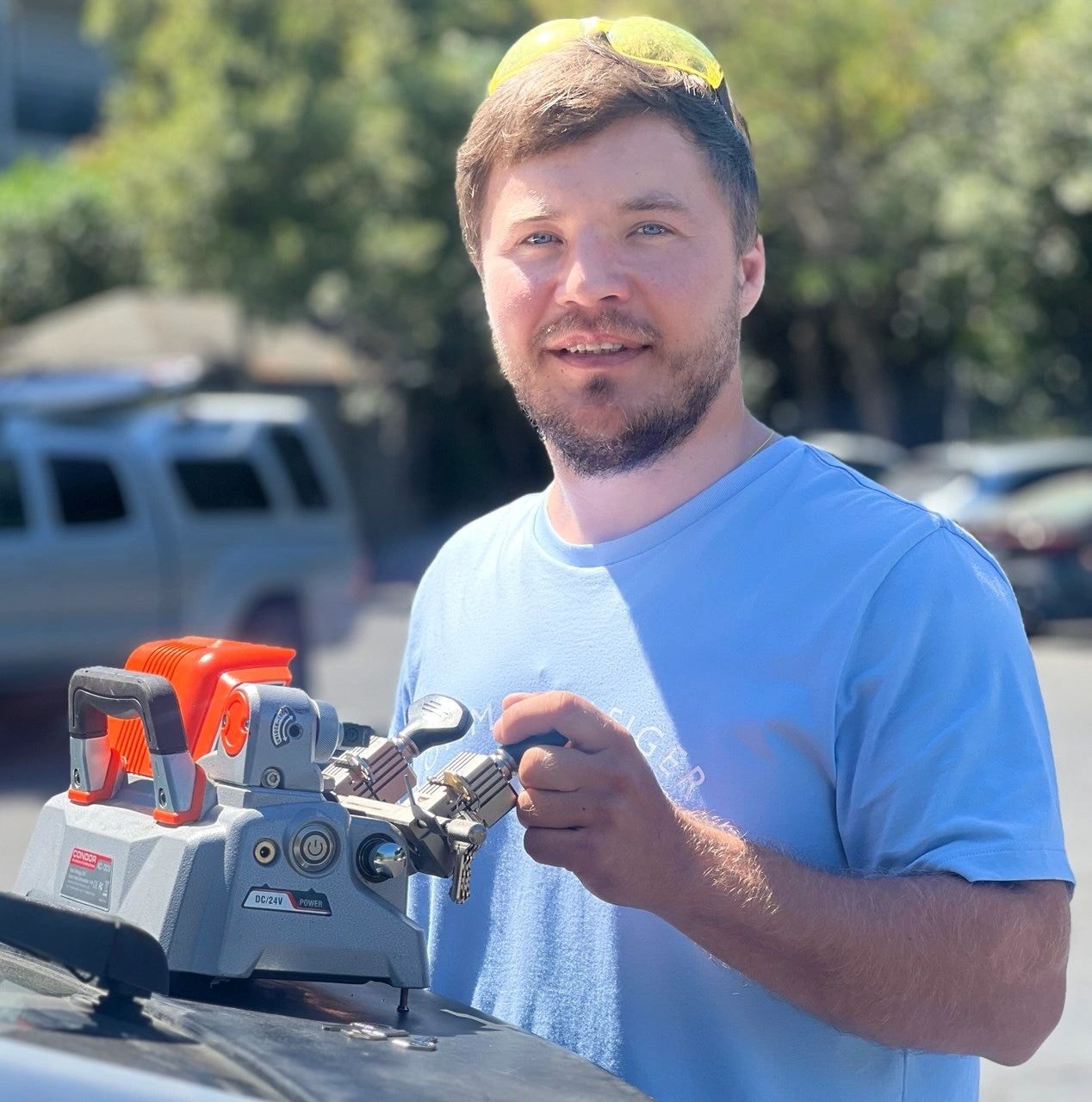 Grigorii, owner and mobile locksmith at Hot Falcon Locksmith Services, with key-cutting equipment
